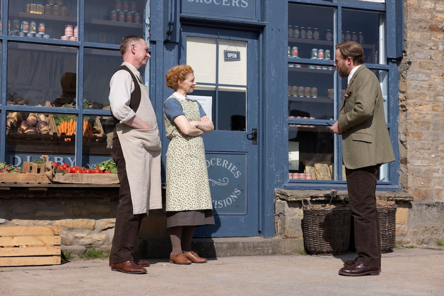 Siegfried (Samuel West) makes his peace with greengrocer Mr. Jubb (Stefan Escreet) and his sister Beryl Jubb (Rayyah McCaul) on the sidewalk outside their shop. 