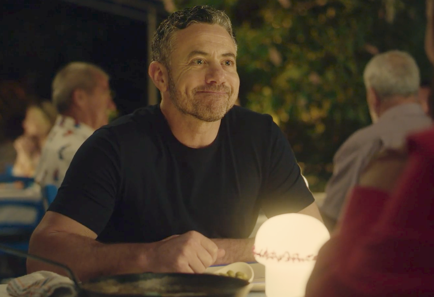 Joe (Warren Brown) smiles across the table at his daughter