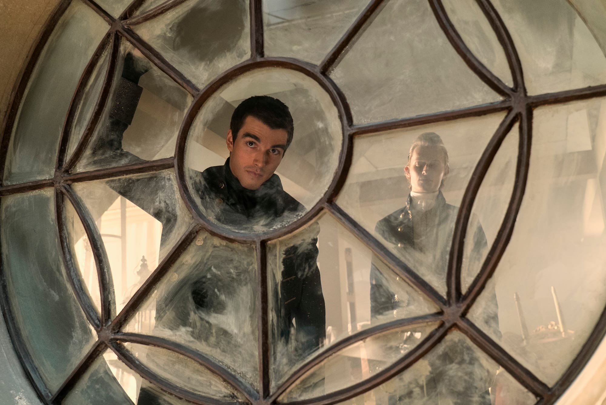 Corey Mylchreest as Young King George, Freddie Dennis as Reynolds in Queen Charlotte: A Bridgerton Story. 