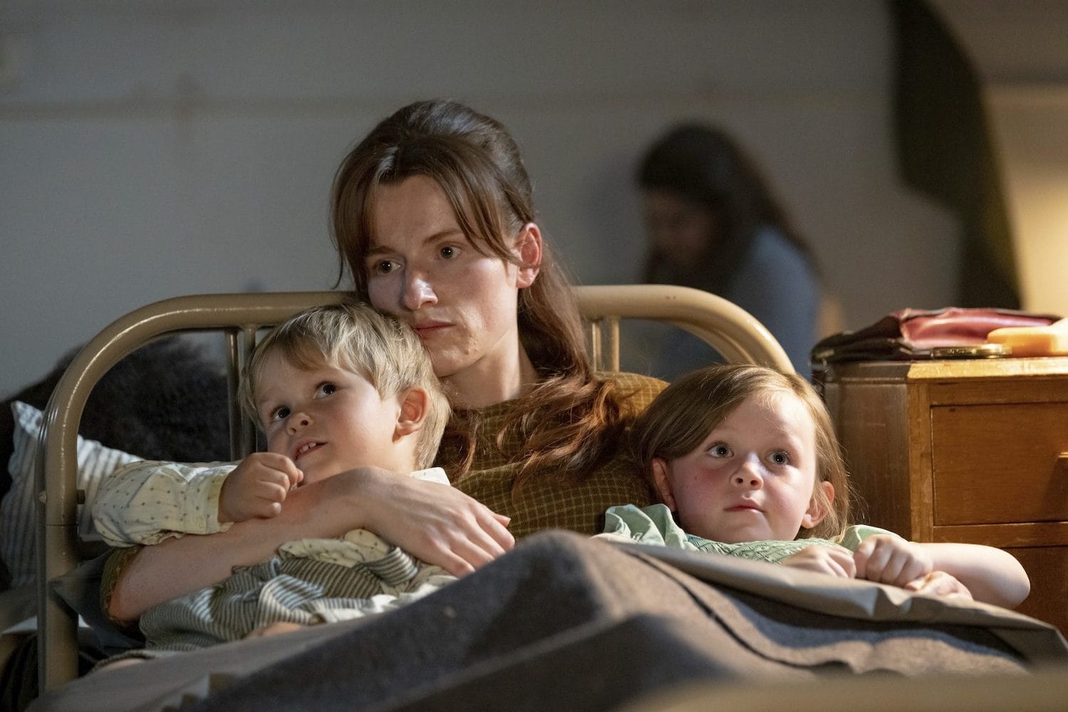 Sandy (Rose Riley) holds her children Peter (Fred Jones) and Ann Marie&nbsp;(Maisie Squibb) close&nbsp;in their bed at the shelter.&nbsp;